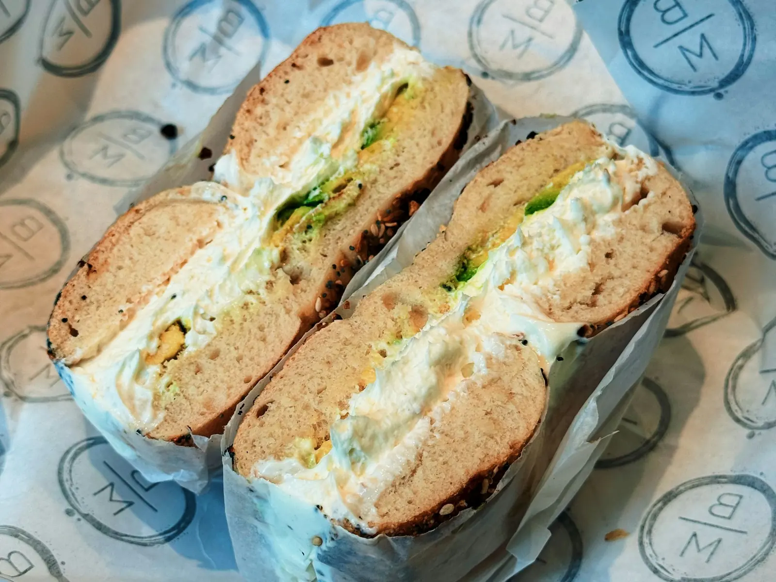 Representative sliced bagel sandwich with cream cheese and green filling